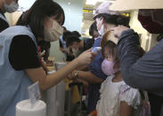 A young participant has her temperature checked before a mock trip abroad at Taipei Songshan Airport in Taipei, Taiwan, Tuesday, July 7, 2020. Dozens of would-be travelers acted as passengers in an activity organized by Taiwan’s Civil Aviation Administration to raise awareness of procedures to follow when passing through customs and boarding their plane at Taipei International Airport. (AP Photo/Chiang Ying-ying)