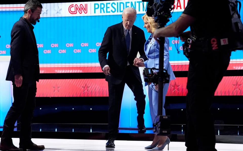 Mr Biden is helped by his wife Jill after last month's presidential debate with Donald Trump