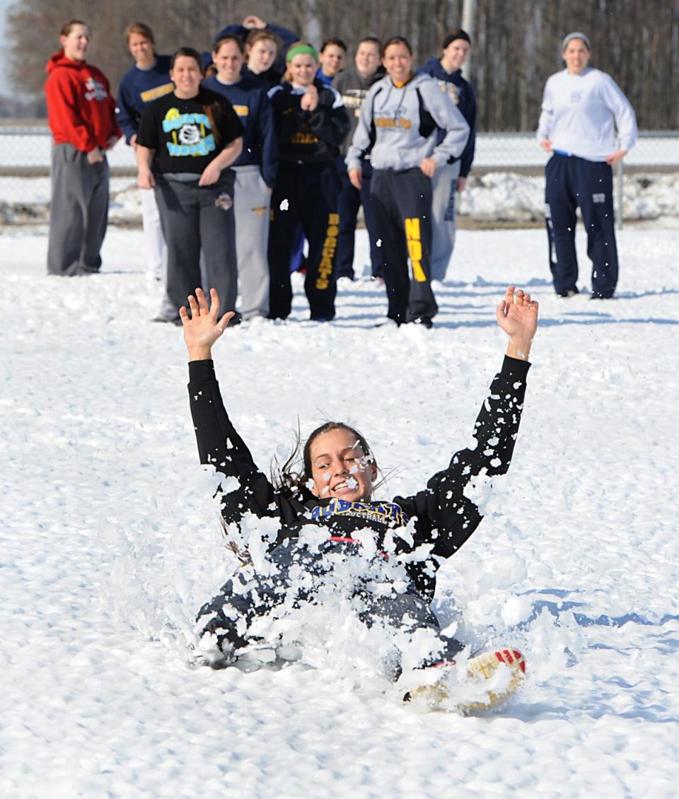 Janie Bunge of Whiteford was the first to slide in the snow as Whiteford High School softball worked on sliding drills on March 14, 2014. Coach Kris Hubbard instructed the players to have arms up, bottoms down and lay on your back as they went through the drills. "Your bottom and back should be wet," said coach Hubbard.