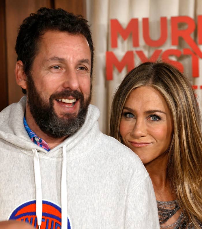 Adam Sandler in a casual hoodie and Jennifer Aniston in an elegant dress at the 