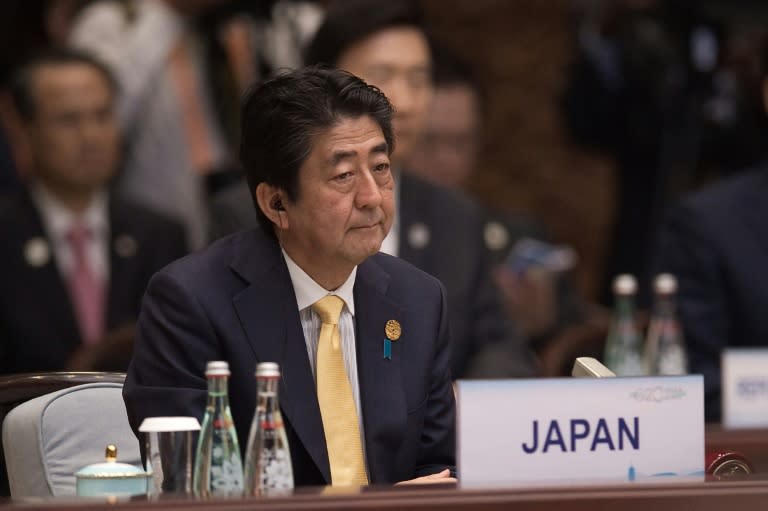 Japan's Prime Minister Shinzo Abe (C) launched a growth plan in 2012 dubbed 'Abenomics'