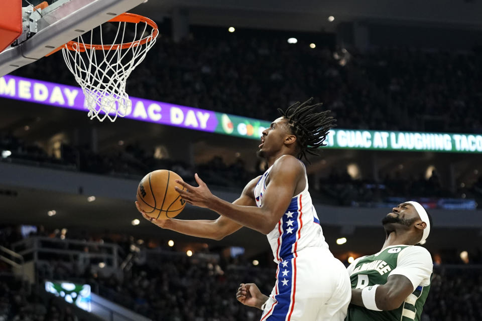 Philadelphia 76ers' Tyrese Maxey, left, shoots past Milwaukee Bucks' Bobby Portis during the first half of an NBA basketball game Saturday, March 4, 2023, in Milwaukee. (AP Photo/Aaron Gash)