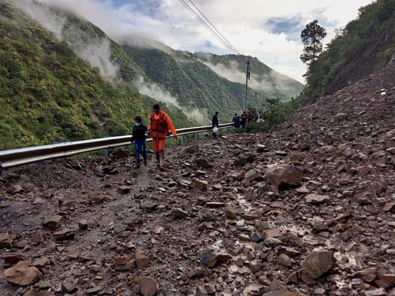 Members of National Disaster Response Force evacuate stranded people following heavy rains at Chhara village