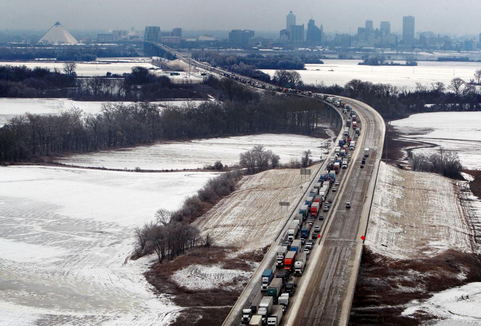 In this March 3, 2014, Ariel photo traffic goes between a stand still and slow crawl on west-bound Interstate 40 just past the Hernando DeSoto Bridge in West Memphis, Ark. Some motorists on the highway in eastern Arkansas were stranded overnight due to lingering icy conditions from a weekend winter storm. An Arkansas highway department spokesman said Tuesday that traffic can't get moving consistently because of repeated accidents. (AP Photo/The Commercial Appeal, Mike Brown)