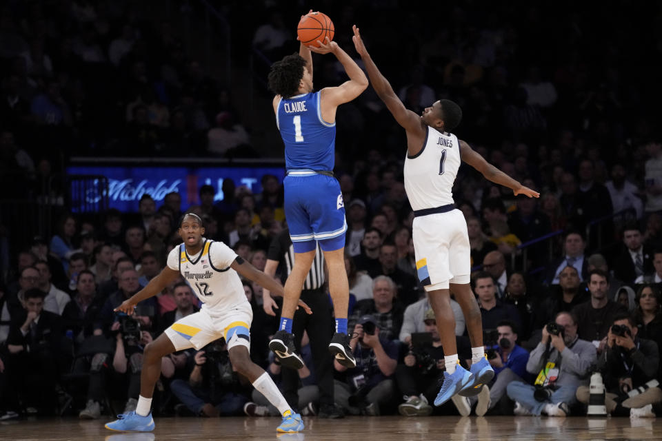 Xavier's Desmond Claude, center, shoots against Marquette's Kam Jones, right, in the first half of an NCAA college basketball game for the championship of the Big East men's tournament, Saturday, March 11, 2023, in New York. (AP Photo/John Minchillo)