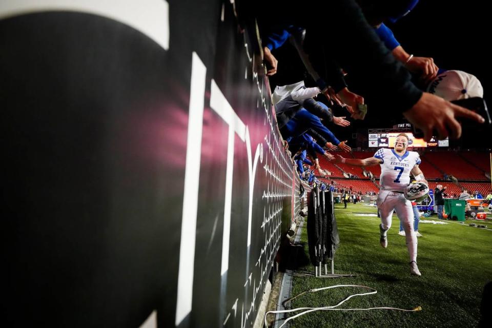 Kentucky quarterback Will Levis (7), who ran for four touchdowns against Louisville, high-fived fans on the way off the field after Saturday night’s 52-21 victory.