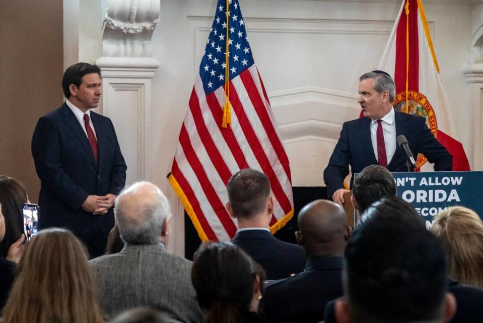 Florida Gov. Ron DeSantis, left, listens to Miami Beach Mayor Steven Meiner speak during an event at the Rum Room in Miami Beach on Feb. 2, 2024.