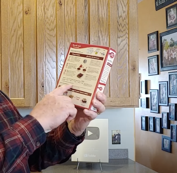 pointing to the high altitude baking instructions on the back of a box of cake