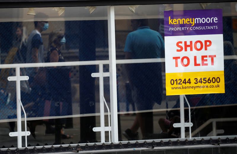 FILE PHOTO: Shoppers are reflected in the window of a closed shop following the outbreak of the coronavirus disease (COVID-19) in Chester, Britain