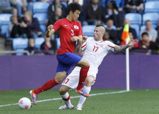 RACIST TWEET EXPULSION: South Korea's Yun Suk-young (L) fights for the ball with Switzerland's Michel Morganella during their men's Group B football match in the London 2012 Olympic Games at the City of Coventry stadium July 29, 2012.