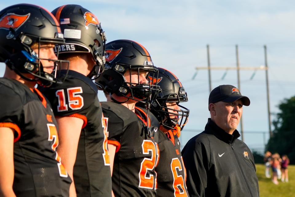 Ryle Raiders and their head coach Michael Engler, right, walk onto the field for the coin toss before the Cooper game Friday.