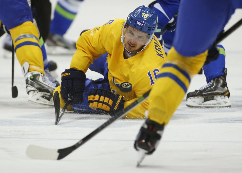 Sweden forward Marcus Kruger dives after the puck against Slovenia in the third period of a men's ice hockey game at the 2014 Winter Olympics, Wednesday, Feb. 19, 2014, in Sochi, Russia. (AP Photo/Julio Cortez)