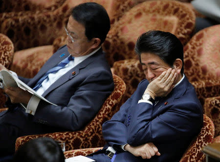 Japan's Prime Minister Shinzo Abe (R) and Deputy Prime Minister and Finance Minister Taro Aso attend a lower house budget committee session at the parliament in Tokyo, Japan, February 13, 2018. Picture taken February 13, 2018. REUTERS/Toru Hanai