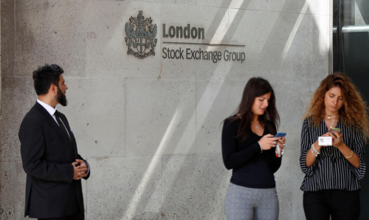 London Stock Exchange People check their mobile phones as they stand outside the entrance of the London Stock Exchange in London, Britain. Aug 23, 2018. REUTERS/Peter Nicholls