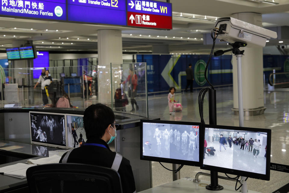 A health surveillance officer monitors passengers arriving at the Hong Kong International airport in Hong Kong, Saturday, Jan. 4, 2020. Hong Kong authorities activated a newly created "serious response" level Saturday as fears spread about a mysterious infectious disease that may have been brought back by visitors to a mainland Chinese city. (AP Photo/Andy Wong)