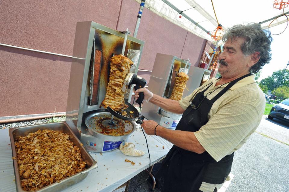 Bobby Karasaras slices chicken at a rotisserie to make gyros during the annual End of Summer Gyro Festival at St. Catherine Greek Orthodox Church in Braintree, Friday, Sept. 9, 2022.