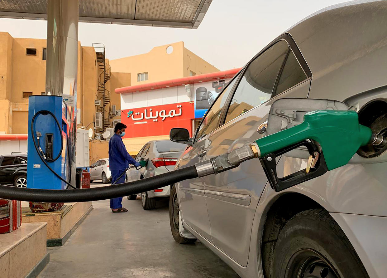 A gas station attendant refills a car at a station in the Saudi capital Riyadh on May 11, 2020. - Saudi Arabia's energy ministry said it had asked oil giant Aramco to make an additional voluntary output cut of one million barrels per day starting from June to support prices. The move will reduce the production of the world's biggest crude exporter to 7.5 million barrels per day, the energy ministry said in a statement cited by the official Saudi Press Agency. (Photo by RANIA SANJAR / AFP) (Photo by RANIA SANJAR/AFP via Getty Images)