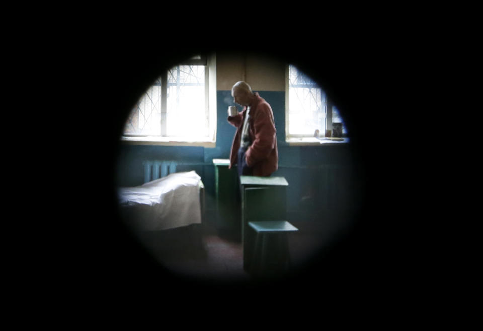 FILE - In this Tuesday, Nov. 20, 2012 file photo, a prisoner in a male prison is seen through a peephole where HIV-positive prisoners receive treatment, care and support in the town of Bucha outside Ukraine's capital Kiev. An estimated 230,000 Ukrainians, or about 0.8 percent of people aged 15 to 49 in a population of 46 million, are living with HIV, the virus that causes AIDS. Some 120,000 are in urgent need of anti-retroviral therapy, which can greatly prolong and improve the quality of their lives. But due to a lack of funds, less than a quarter are receiving the drugs, one of the lowest levels in the world. (Photo/Efrem Lukatsky)