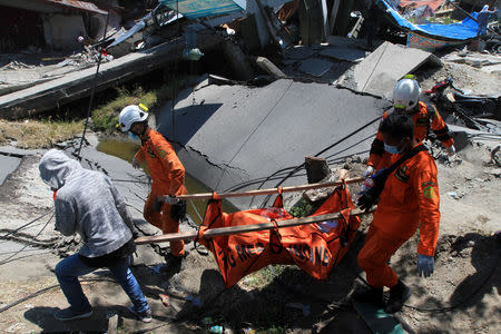 Indonesian rescue workers evacuate the body of a victim of an earthquake in Petabo, South Palu, Central Sulawesi, Indonesia, October 1, 2018, in this photo taken by Antara Foto. Antara Foto/Akbar Tado via REUTERS