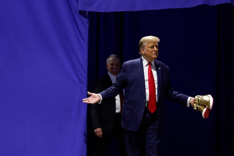 Former President Donald Trump, holding a pair of his signature sneakers during a February appearance in Philadelphia, is in the jury-selection phase of his hush money trial in New York. (Photo by Chip Somodevilla/Getty Images)