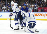 Tampa Bay Lightning's goaltender Andrei Vasilevskiy, right, makes a save as Toronto Maple Leafs' William Nylander (88) and Lightning's Victor Hedman (77) work next to him during the second period of an NHL hockey game Wednesday, April 3, 2024, in Toronto. (Chris Young/The Canadian Press via AP)