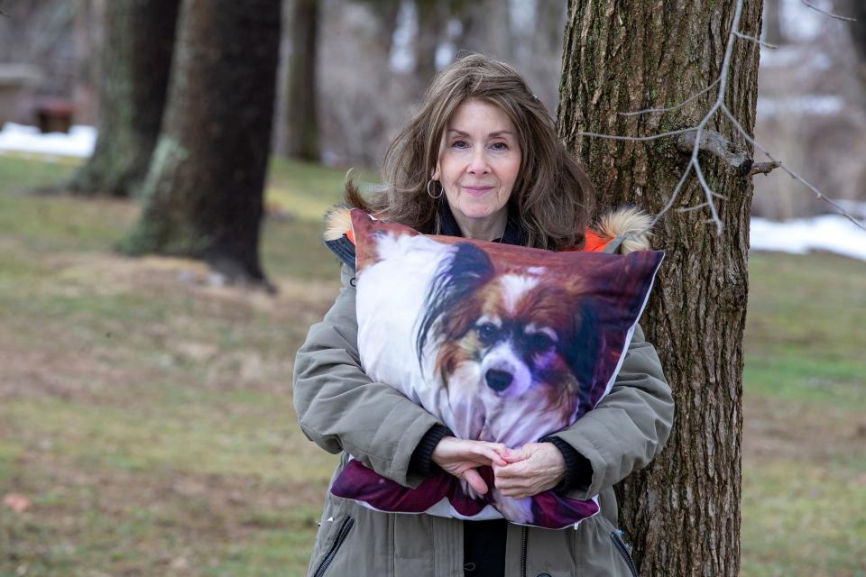 Rhonda Bomwell, of Somerset, N.J., holds a pillow Monday, March 1, 2021, with the image of Pierre, her 9-year-old Papillon, that died June 1, 2020, from side effects of wearing a popular flea and tick collar for pets.