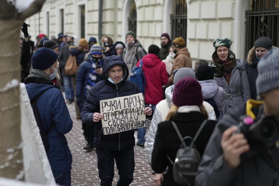 FILE - A demonstrator holds a poster saying, "Hands off Memorial, freedom for political prisoners" as people gather in front of the Russian Supreme Court in Moscow, Russia, on Tuesday, Dec. 14, 2021. The court ordered the closure of Memorial, one of the country's oldest and most prominent human rights organizations. It drew acclaim for highlighting repression in the Soviet Union and was awarded the 2022 Nobel Peace Prize for its work. (AP Photo, File)