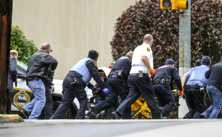 Police and medics rush a person on a stretcher outside the synagogue. Source: AP