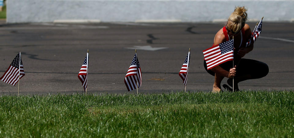 <p>Debbie Totten of Phoenix, Arizona places American flags at the Dignity Memorial Mortuary honoring the late Sen. John McCain on Aug. 26, 2018 in Phoenix, Ariz. (Photo: Ralph Freso/Getty Images) </p>