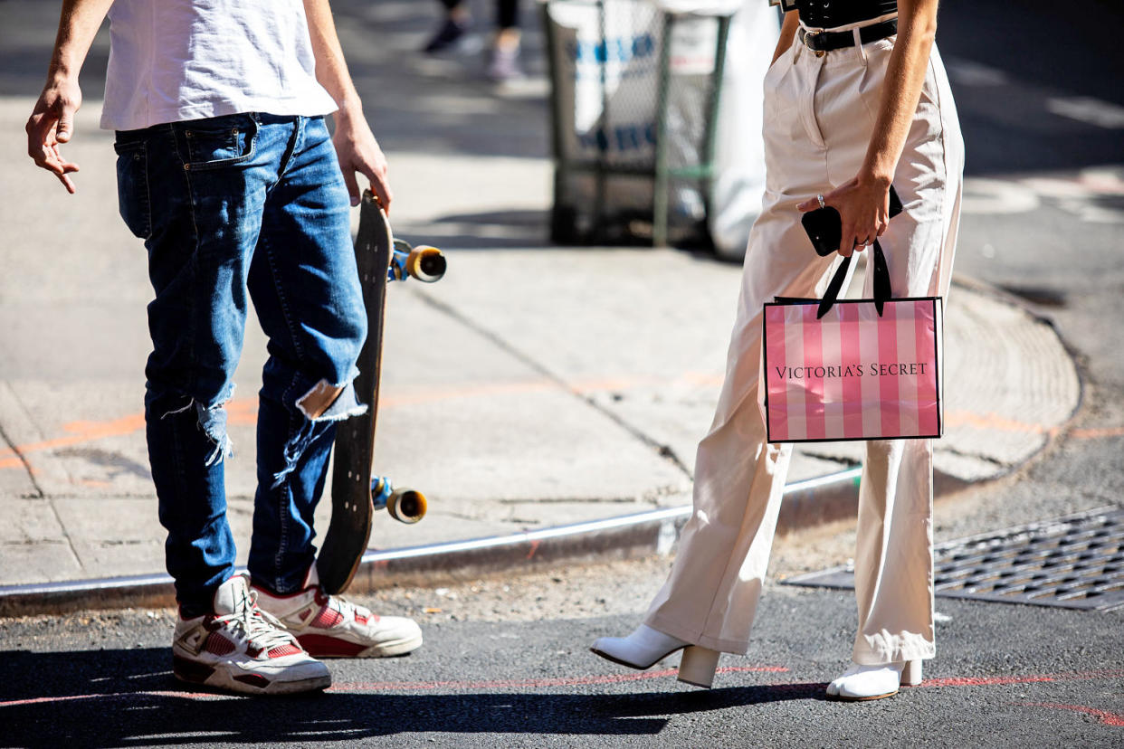 A pedestrian carries a Victoria's Secret shopping bag while waiting to cross a street in New York. (Demetrius Freeman / Bloomberg via Getty Images file)