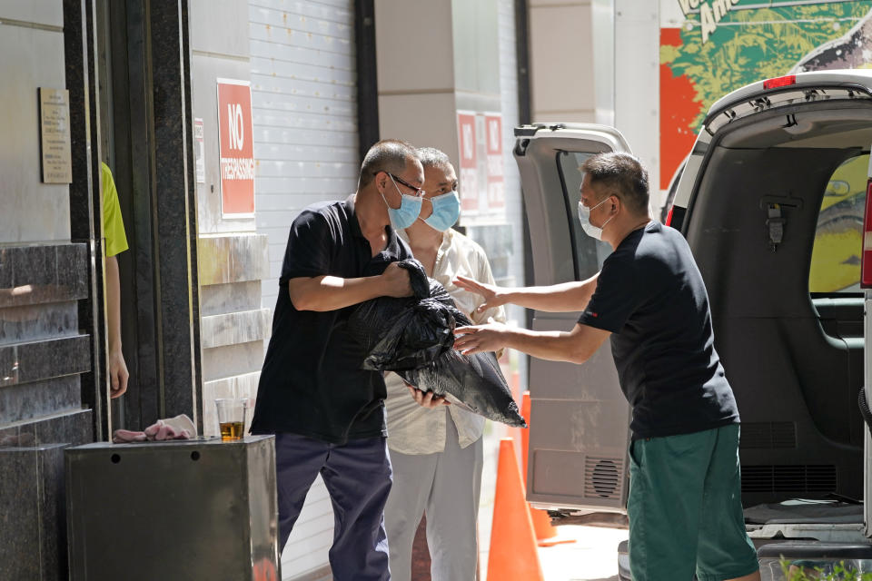 People remove bags from inside the Chinese Consulate as they load a van Thursday, July 23, 2020, in Houston. China says “malicious slander" is behind an order by the U.S. government to close its consulate in Houston, and maintains that its officials have never operated outside ordinary diplomatic norms. (AP Photo/David J. Phillip)