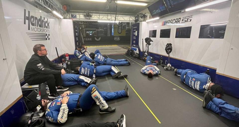 Hendrick Motorsports crew members rest in the Garage 56 paddock in the early morning hours at Le Mans
