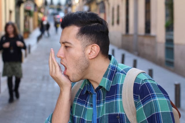 Man checking his own breath