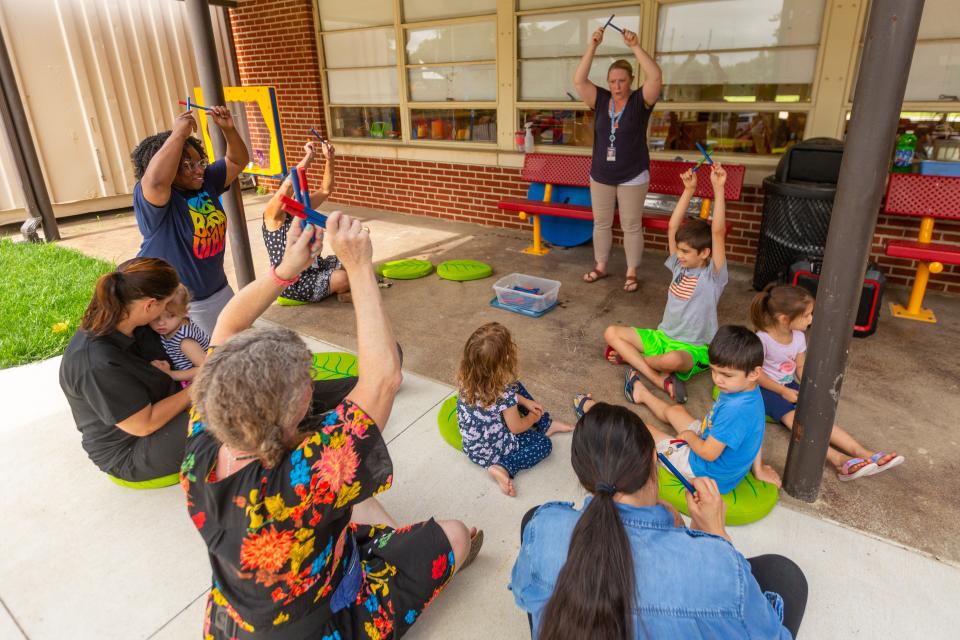 Sheri Bounous, a parent educator with Topeka USD 501's Parents as Teachers program, guides a group of parents and children through a song activity at a play session Friday morning at Quinton Heights Education Center.