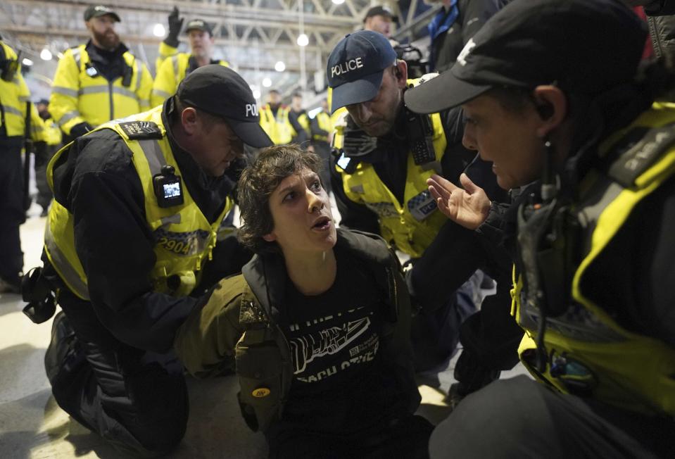 Police officers detain a pro-Palestinian protester that took part in a sit-in demonstration at Waterloo Station calling for a ceasefire in Gaza, in London, Saturday, Nov. 18, 2023. (Stefan Rousseau/PA via AP)