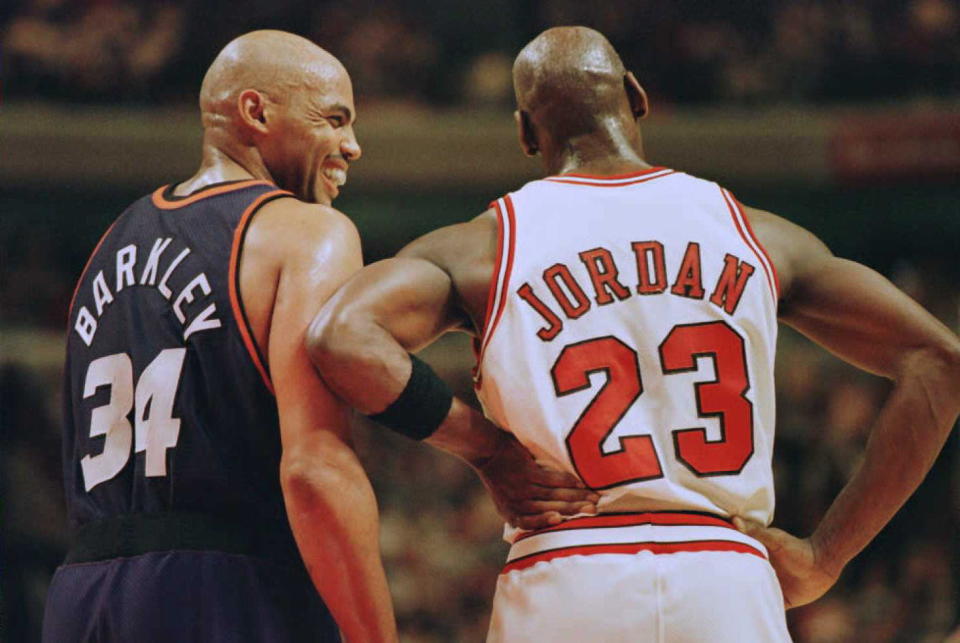 FILE: Phoenix Suns forward Charles Barkley (34) laughs at a foul call with Chicago Bulls guard Michael Jordan (23) in the first half 28 January 1996 at the United Center in Chicago. / Credit: BRIAN BAHR/AFP via Getty Images