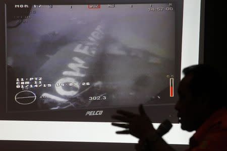 Head of the National Search and Rescue Agency Fransiskus Bambang Soelistyo is seen with an image believed to be of the fuselage of AirAsia Flight QZ8501, taken by an underwater ROV provided by the Singaporean Navy, during a news conference in Jakarta January 14, 2015. REUTERS/Pius Erlangga