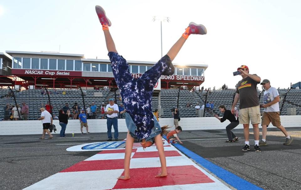 Chloee Dean, 11 years old, does a round-off at the start/finish line at North Wilkesboro Speedway on May 10, 2023. The speedway held an open house for fans to see the new renovations to the track, which hosted the All-Star race in 2023. The last race at the speedway was in 1996.