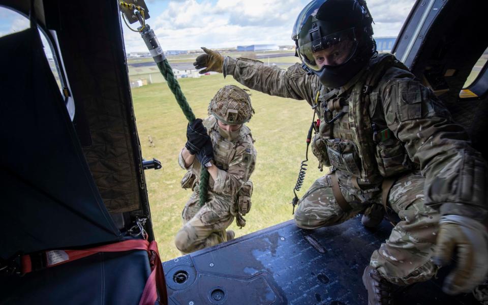 Paratroopers have taken to the skies to learn to descend from a hovering helicopter by rope