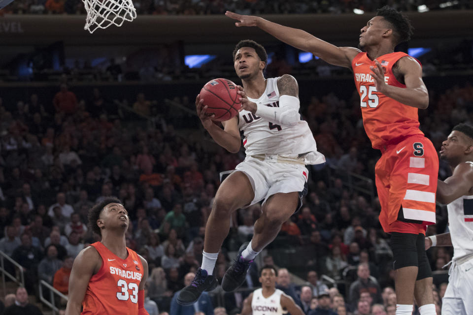 Connecticut guard Jalen Adams (4) goes to the basket against Syracuse guard Tyus Battle (25) during the second half of an NCAA college basketball game in the 2K Empire Classic, Thursday, Nov. 15, 2018, at Madison Square Garden in New York. Connecticut won 83-76. (AP Photo/Mary Altaffer)