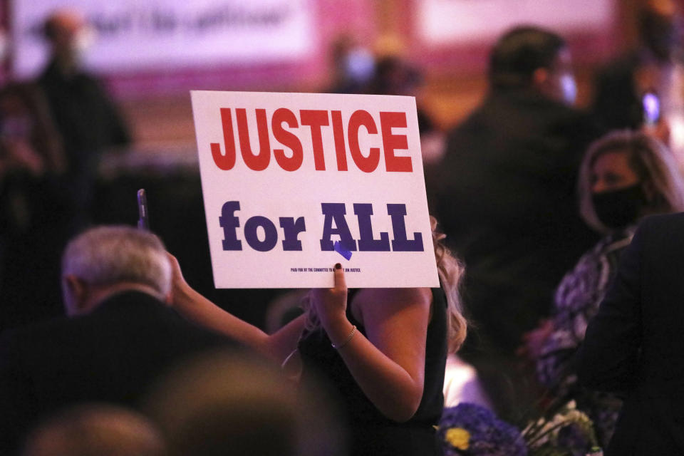 A member of the audience holds a "Justice for All" sign during West Virginia Gov. Jim Justice's election night watch party at The Greenbrier Resort, Tuesday, Nov. 3, 2020, in White Sulphur Springs, W.Va. (AP Photo/Chris Jackson)