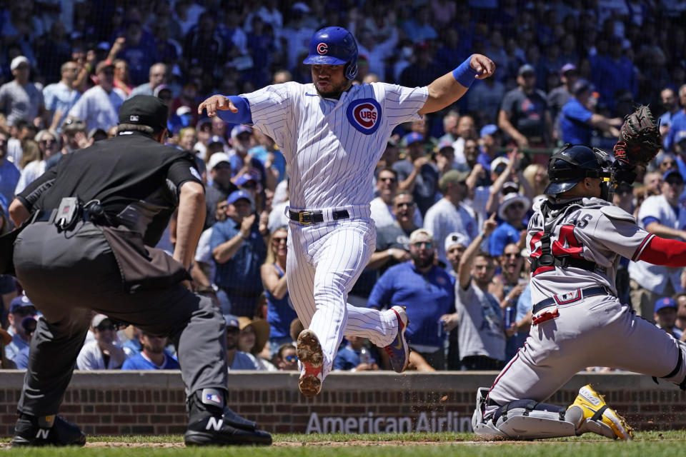 Chicago Cubs' Willson Contreras, center, scores on a two-run single by Jonathan Villar as Atlanta Braves catcher William Contreras waits for the ball during the first inning of a baseball game in Chicago, Saturday, June 18, 2022. (AP Photo/Nam Y. Huh)