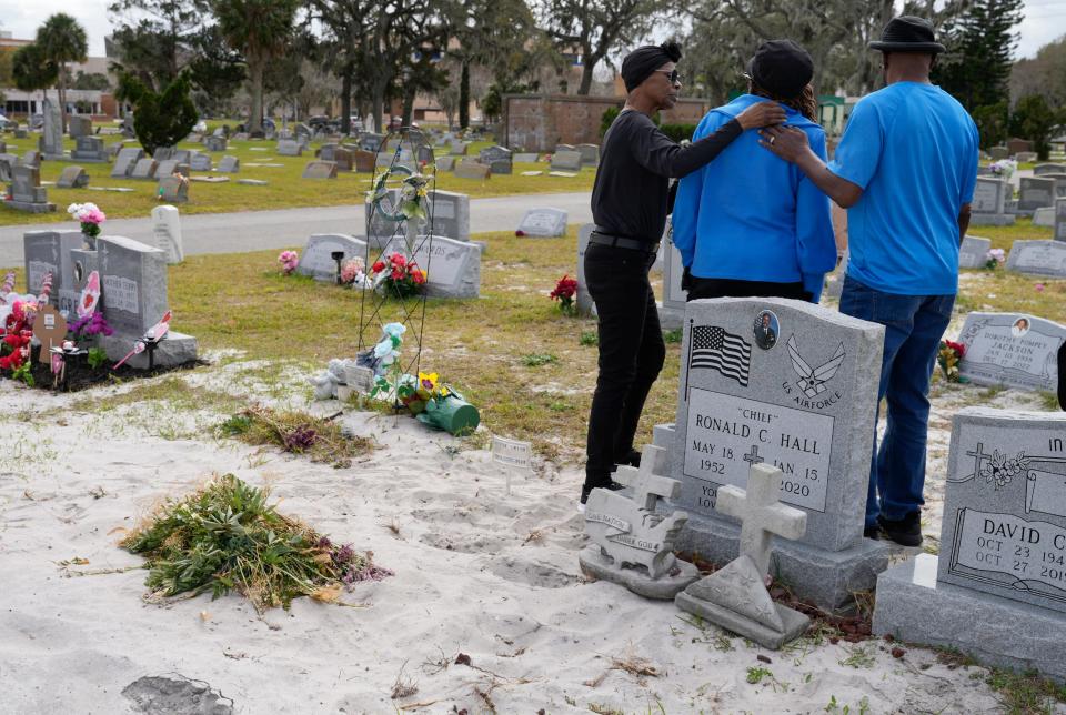 Pamela Hall, center, is comforted at the gravesite of her daughter, Eleecia Smith, while visiting Greenwood Cemetery in Daytona Beach on Feb. 8.