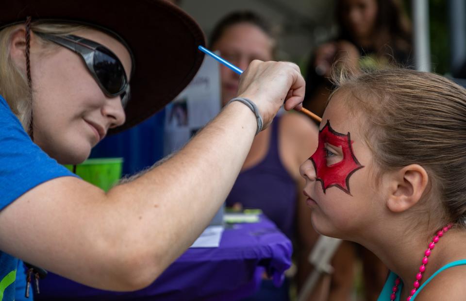 Stevie Miller, 6, gets her face painted by Clarissa Summers, a volunteer at the Taylor School District tent at Heritage Park, during the 175th Anniversary of Taylor on Aug 6, 2022.