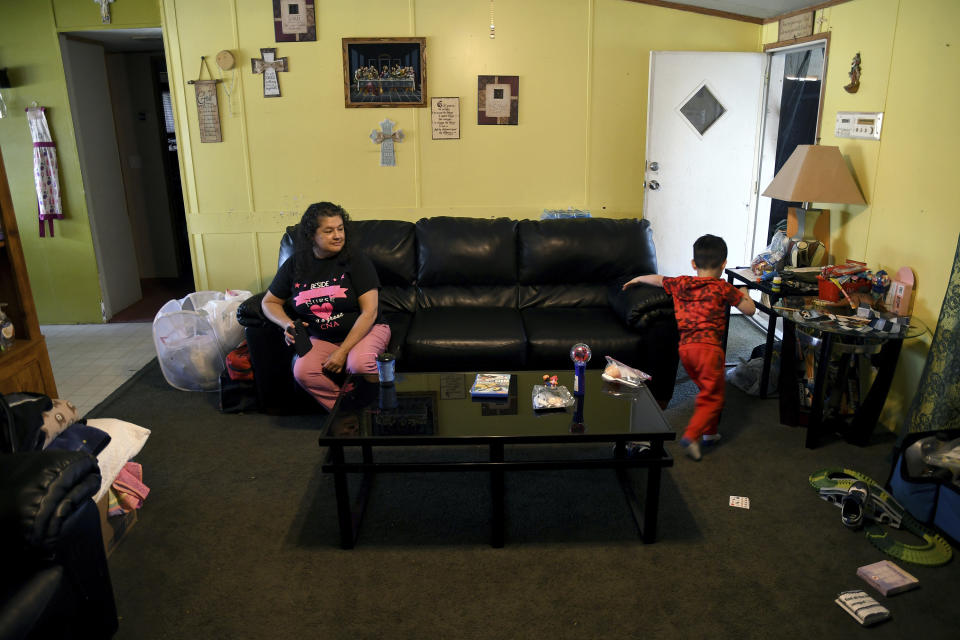 Martina Gonzales and her grandson, Lukas Lee Mora, 4, in their home in Las Vegas, N.M., on Tuesday, May, 3, 2022. Flames raced across more of New Mexico's pine-covered mountainsides Tuesday, charring more than 217 square miles (562 square kilometers) over the last several weeks. Gonzales and her husband have packed up their valuables and are ready to leave the area if the fire tops the ridge behind their house. (AP Photo/Thomas Peipert)