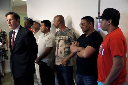 Attorney Steven Arenson stands with immigrant car wash workers at a news conference, where 18 car wash workers received the final part of a $1.6 million federal court settlement for unpaid wages after a five-year case against four car washes in New York City and New Jersey, in Manhattan, New York City, U.S., June 21, 2016. REUTERS/Mike Segar