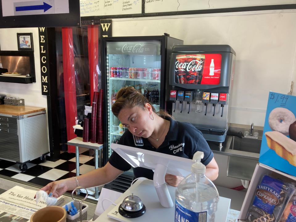 Valentina Muro rings up a customer at the Broadway Café in Van Horn, Texas, on Sunday, July 18, 2021, just days before Blue Origin plans to launch a manned spacecraft from its spaceport about 25 miles outside of the West Texas town. (AP Photo/Sean Murphy)