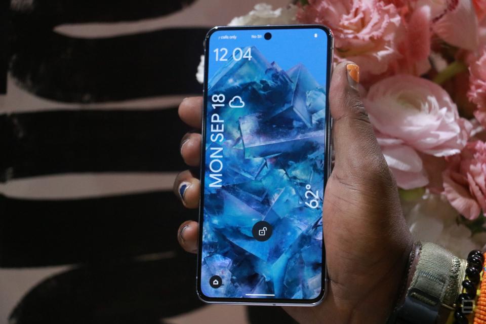 The Pixel 8 held in mid-air with its screen facing out.