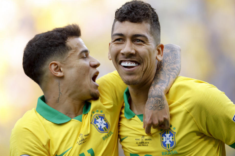 Brazil's Roberto Firmino, right, celebrates with Phlippe Coutinho after scoring his side's second goal against Peru during a Copa America Group A soccer match at the Arena Corinthians in Sao Paulo, Brazil, Saturday, June 22, 2019. (AP Photo/Victor R. Caivano)