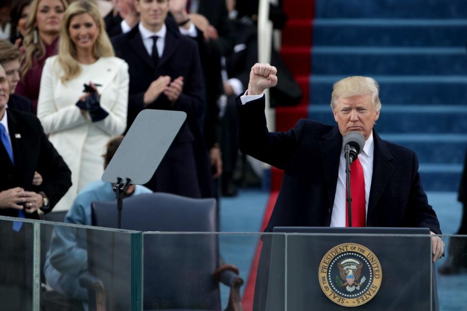 Trump raises a fist after his inauguration on 20 January 2017 (Getty Images)